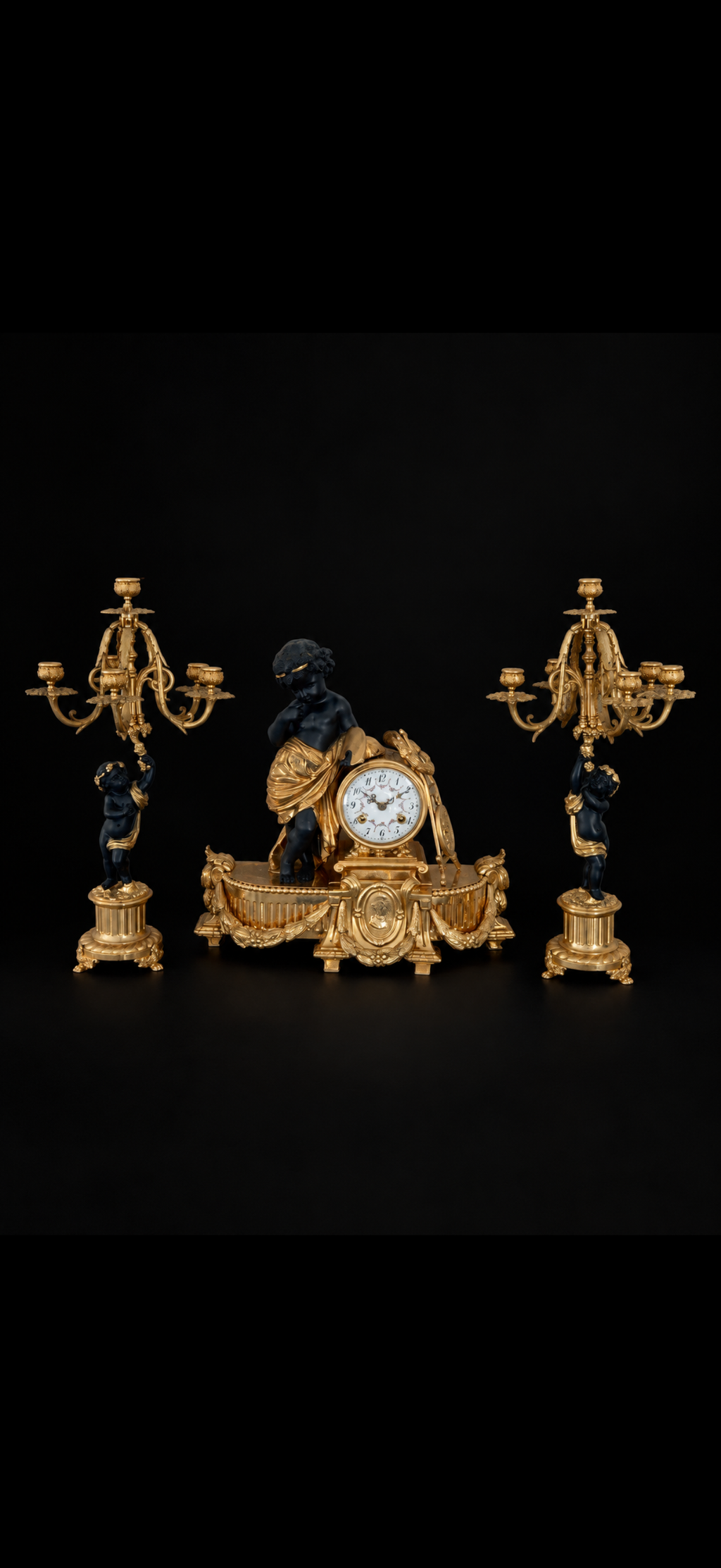 Garniture de cheminée d'après Auguste Moreau, pendule et paire de candélabres aux putti, bronze doré et patiné