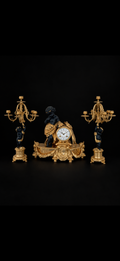 Garniture de cheminée d'après Auguste Moreau, pendule et paire de candélabres aux putti, bronze doré et patiné